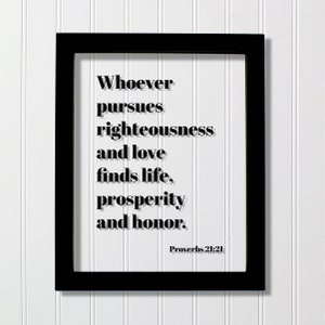 May include: Black framed print with a white background and black text that reads "Whoever pursues righteousness and love finds life, prosperity and honor. Proverbs 21:21"