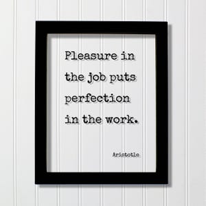 以下が含まれることがあります： 黒い長方形のフレームに、タイプライター風の黒い文字で「Pleasure in the job puts perfection in the work.」と書かれた白いプリントが入っています。白い背景の右下隅には「Aristotle」という名前が印刷されています。
