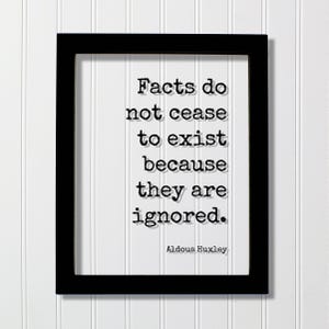 May include: A framed print with a black frame and white background. The print features the quote "Facts do not cease to exist because they are ignored." by Aldous Huxley, in a typewriter-style font.