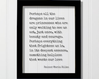 May include: A black rectangular frame containing a white print with the quote: Perhaps all the dragons in our lives are princesses who are only waiting to see us act, just once, with beauty and courage. Perhaps everything that frightens us is, in its deepest essence, something helpless that wants our love. Rainer Maria Rilke.