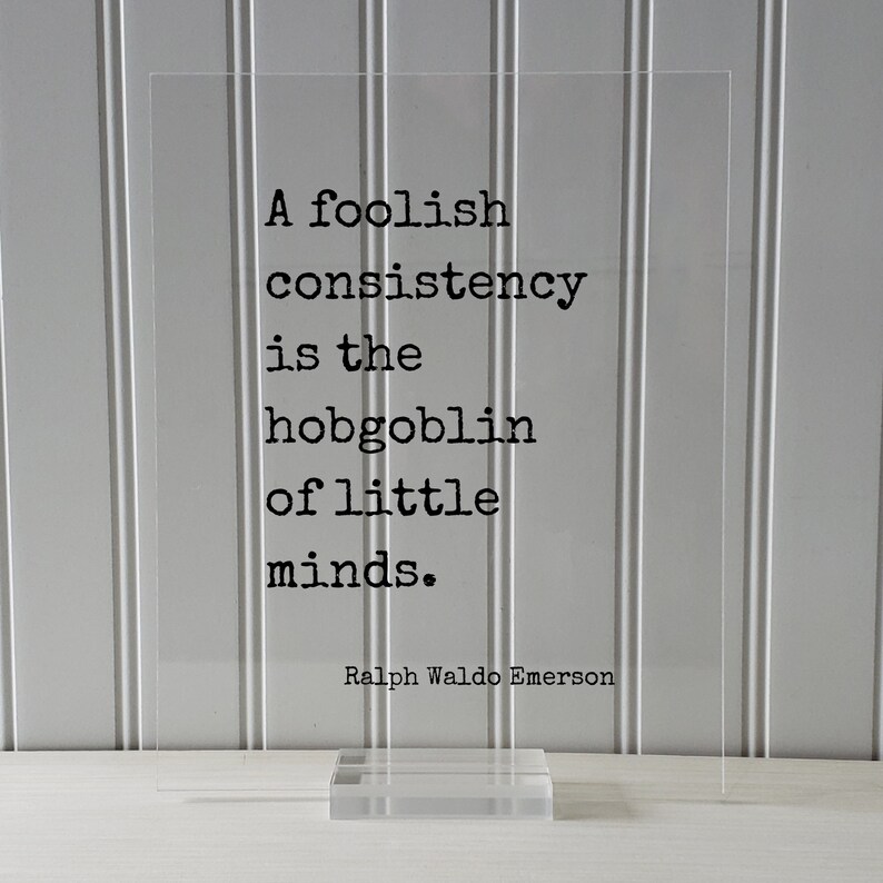 May include: A clear acrylic sign with a black quote that reads "A foolish consistency is the hobgoblin of little minds."  The quote is attributed to Ralph Waldo Emerson.
