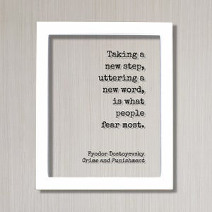 May include: A white framed print featuring a black and white quote from Fyodor Dostoevsky's Crime and Punishment. The quote reads: "Taking a new step, uttering a new word, is what people fear most."