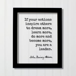 以下が含まれることがあります： 黒い長方形のフレームに、白いプリントと黒いテキスト「If your actions inspire others to dream more, learn more, do more and become more, you are a leader.」が収められています。引用文はジョン・クインシー・アダムズによるもので、黒い筆記体で書かれています。