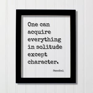 Op de afbeelding: Een zwarte rechthoekige lijst met een witte print met de zwarte tekst in typemachinestijl: One can acquire everything in solitude except character. De naam Stendhal staat in de rechterbenedenhoek van het witte papier gedrukt.