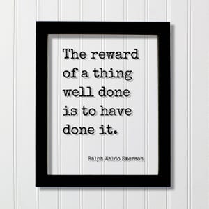 Op de afbeelding: Een zwarte rechthoekige lijst met een witte print met de zwarte tekst in typemachinestijl: The reward of a thing well done is to have done it. Ralph Waldo Emerson. Het citaat is gecentreerd in de lijst met een duidelijk leesbaar lettertype.