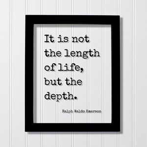 May include: A rectangular black frame containing a white print with the black typewriter-style text: It is not the length of life, but the depth. Ralph Waldo Emerson. The quote is centered in the frame with a clear, legible font and drop shadow.