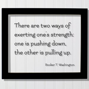 May include: Black framed print with a white background and a quote by Booker T. Washington: "There are two ways of exerting one's strength: one is pushing down, the other is pulling up."