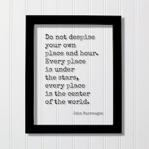 Op de afbeelding: Een zwarte rechthoekige lijst met een witte print met de zwarte tekst in typemachinestijl: Do not despise your own place and hour. Every place is under the stars, every place is the center of the world. Het citaat is ondertekend door John Burroughs.