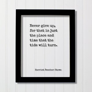 May include: Black framed print with the quote "Never give up, for that is just the place and time that the tide will turn." by Harriet Beecher Stowe. The text is in a classic serif font on a white background.