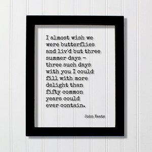 Op de afbeelding: Een zwarte rechthoekige lijst met een witte print met de zwarte tekst: I almost wish we were butterflies and liv'd but three summer days - three such days with you I could fill with more delight than fifty common years could ever contain. John Keats.