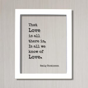 Op de afbeelding: Een witte rechthoekige lijst met een doorzichtige plaat met zwarte tekst in typemachine-stijl die luidt: That Love is all there is, Is all we know of Love. De naam Emily Dickinson staat in de rechterbenedenhoek op de doorzichtige plaat.