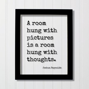 May include: Black framed print with the quote "A room hung with pictures is a room hung with thoughts." The text is in a typewriter font on a white background. The author's name, Joshua Reynolds, is below the quote.