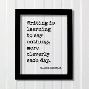 May include: A black rectangular frame containing a white print with the black typewriter-style text: Writing is learning to say nothing, more cleverly each day. The author name William Allingham is printed in the bottom right corner of the white paper.
