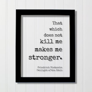 Puede incluir: Impresión enmarcada en negro con fondo blanco y texto negro que dice "That which does not kill me makes me stronger." El texto se atribuye a Friedrich Nietzsche y "Twilight of the Idols".