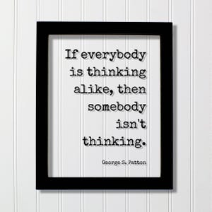 Op de afbeelding: Een zwarte rechthoekige lijst met een witte print met de zwarte tekst in typemachinestijl: If everybody is thinking alike, then somebody isn't thinking. Het citaat wordt onderaan het witte papier toegeschreven aan George S. Patton.