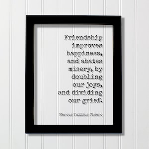 May include: A black rectangular frame containing a white print with the black text: Friendship improves happiness, and abates misery, by doubling our joys, and dividing our grief. Marcus Tullius Cicero. The text is in a typewriter-style font.