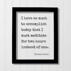 Puede incluir: Un marco rectangular negro que contiene una impresión blanca con el texto negro estilo máquina de escribir: I have so much to accomplish today that I must meditate for two hours instead of one. El nombre Mahatma Gandhi aparece abajo a la derecha.