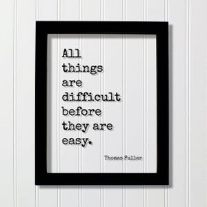 Puede incluir: Un marco rectangular negro que contiene una impresión blanca con el texto negro estilo máquina de escribir: All things are difficult before they are easy. El nombre Thomas Fuller está impreso en la esquina inferior derecha del fondo blanco.
