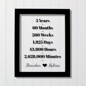 Peut inclure: Impression encadrée en noir avec du texte blanc qui lit "5 Years", "60 Months", "260 Weeks", "1,825 Days", "43,800 Hours", et "2,628,000 Minutes". Le texte est séparé par des lignes avec une petite ligne noire entre chaque ligne. Le bas de l'impression lit "Brandon" avec un symbole de cœur noir et "Melissa".