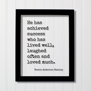 Puede incluir: Un marco rectangular negro que contiene una impresión blanca con el texto negro estilo máquina de escribir: He has achieved success who has lived well, laughed often and loved much. El nombre Bessie Anderson Stanley aparece abajo.