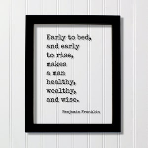 May include: Black framed print with a white background and a quote in black text: "Early to bed, and early to rise, makes a man healthy, wealthy, and wise." The quote is attributed to Benjamin Franklin.