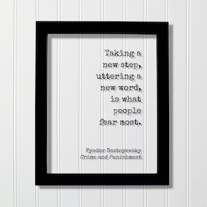 May include: Black and white framed print with a quote by Fyodor Dostoevsky from Crime and Punishment: "Taking a new step, uttering a new word, is what people fear most."