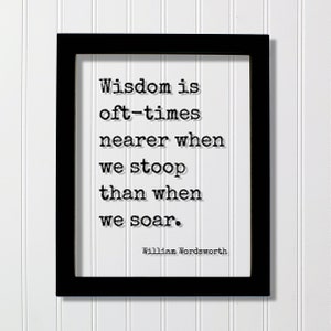 May include: Black framed print with a white background and a quote in black text: "Wisdom is oft-times nearer when we stoop than when we soar." The quote is attributed to William Wordsworth.