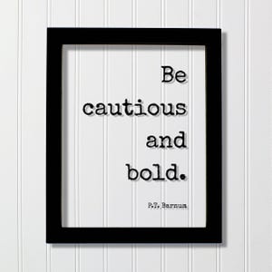 Op de afbeelding: Een rechthoekige zwarte lijst met een witte print met de zwarte tekst in typemachinestijl "Be cautious and bold." gevolgd door de toeschrijving "P.T. Barnum" in een kleiner lettertype in de rechterbenedenhoek van de witte achtergrond.