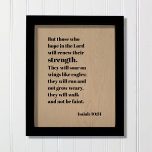 May include: A rectangular wall art piece featuring a black frame surrounding a light wood-toned panel. The panel displays black text that reads: But those who hope in the Lord will renew their strength. They will soar on wings like eagles; they will run and not grow weary, they will walk and not be faint. Isaiah 40:31.