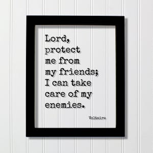 Könnte beinhalten: Ein schwarzer rechteckiger Rahmen mit einem weißen Druck, der den schwarzen Text im Schreibmaschinenstil enthält: Lord, protect me from my friends; I can take care of my enemies. Der Name Voltaire steht in der unteren rechten Ecke.