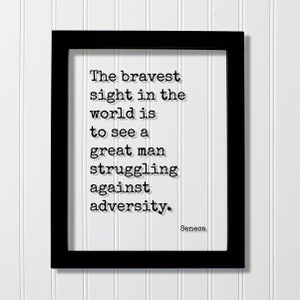 May include: Black and white framed print with a quote by Seneca: "The bravest sight in the world is to see a great man struggling against adversity."