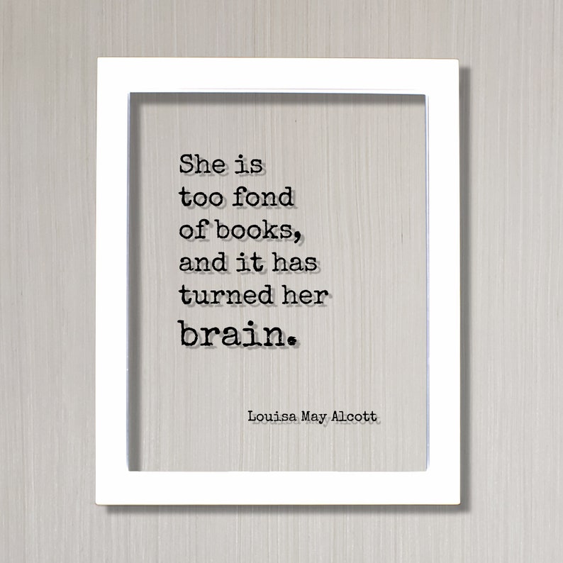 May include: White framed print with a black and white quote by Louisa May Alcott: "She is too fond of books, and it has turned her brain."