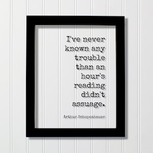 May include: Black framed print with a white background and a quote in black text: "I've never known any trouble than an hour's reading didn't assuage."  The quote is attributed to Arthur Schopenhauer.