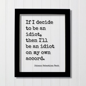May include: A black rectangular frame containing a white print with the black typewriter-style text: If I decide to be an idiot, then I'll be an idiot on my own accord. The name Johann Sebastian Bach is printed in smaller text at the bottom right.