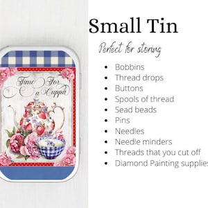 May include: A small, white tin with a blue and white checked lid. The tin has a colourful image of a teapot and teacup with the text "Time For a Cuppa".