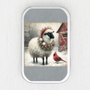 Pode incluir: Imagem com tema de inverno com uma ovelha usando um gorro de Papai Noel e uma coroa festiva. Um cardeal vermelho está por perto, com um celeiro vermelho ao fundo. A cena se passa em uma paisagem nevada.