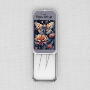 May include: An open metal tin featuring a watercolour illustration of a moth and flowers. The tin is labelled "Night Things". Several needles are visible inside the tin.