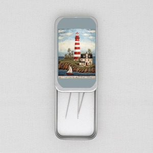 May include: A rectangular metal tin with a hinged lid, depicting a red and white striped lighthouse on a rocky island. The text "This Land is Your Land" is at the bottom. The tin contains several needles.