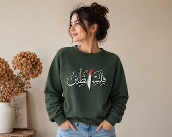 Op de afbeelding: Donkergroene sweatshirt met witte Arabische kalligrafie en een Palestijns vlagontwerp. De crew neck sweatshirt is gemaakt van een zacht materiaal.