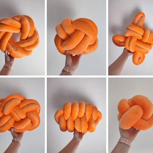 Könnte beinhalten: Satz mit fünf orangefarbenen Knotenkissen. Die Kissen sind aus weichem, plüschem Stoff gefertigt und eignen sich perfekt, um jedem Raum einen Hauch von Farbe und Gemütlichkeit zu verleihen.