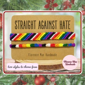 May include: Two handmade woven bracelets featuring rainbow-colored patterns on a tan display card. The card displays the text STRAIGHT AGAINST HATE and Florence Mae Handmade. A small label at the bottom reads two styles to choose from.