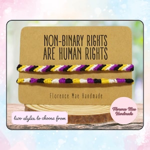 May include: Two non-binary pride bracelets with yellow, white, purple, and black stripes. The bracelets are on a brown card with the text "NON-BINARY RIGHTS ARE HUMAN RIGHTS" and "Florence Mae Handmade".
