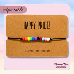 May include: A rainbow beaded bracelet on a brown card with the text "HAPPY PRIDE!" and "Florence Mae Handmade".