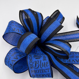 May include: Blue and black striped ribbon with the text "Love our Blue, Protect & Serve, Law Enforcement" printed on it.