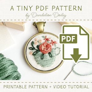 May include: A tiny floral embroidery pattern for a necklace, featuring a rose and leaves in shades of green and pink. The pattern is available as a printable PDF download with a video tutorial.