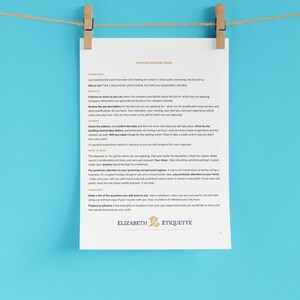 Puede incluir: Una hoja de papel blanca sobre un fondo azul, colgada de una cuerda con pinzas de madera. El papel tiene el título "Guía de etiqueta para entrevistas" e incluye consejos para prepararse para una entrevista de trabajo, como investigar la empresa, planificar tu atuendo y preparar preguntas para hacer.