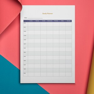 May include: A white study planner with a grid layout for scheduling classes and activities. The planner includes sections for each day of the week and time slots from 8 am to 8 pm. The background is a combination of red, blue, and yellow paper.