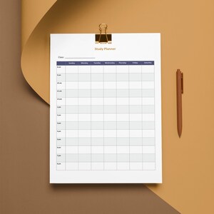 May include: A white study planner with a gold binder clip and a brown pen. The planner has a grid layout for scheduling classes from Sunday to Saturday, with time slots from 8 am to 8 pm. The words "Study Planner" are at the top.