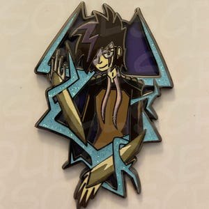 May include: A limited edition enamel pin featuring a stylized anime character with black hair and a black and brown outfit. The pin has a light blue lightning bolt design with glitter accents. Text on the pin reads "2025 DM-664 OC Enamel Pin" and "Limited Edition."