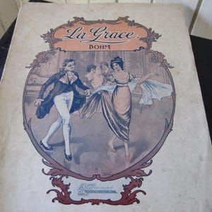 May include: Antique sheet music cover titled "La Grace" with a vintage illustration of people dancing. The artwork features a man in a black coat and white pants, and a woman in a long dress. The cover has a decorative border.